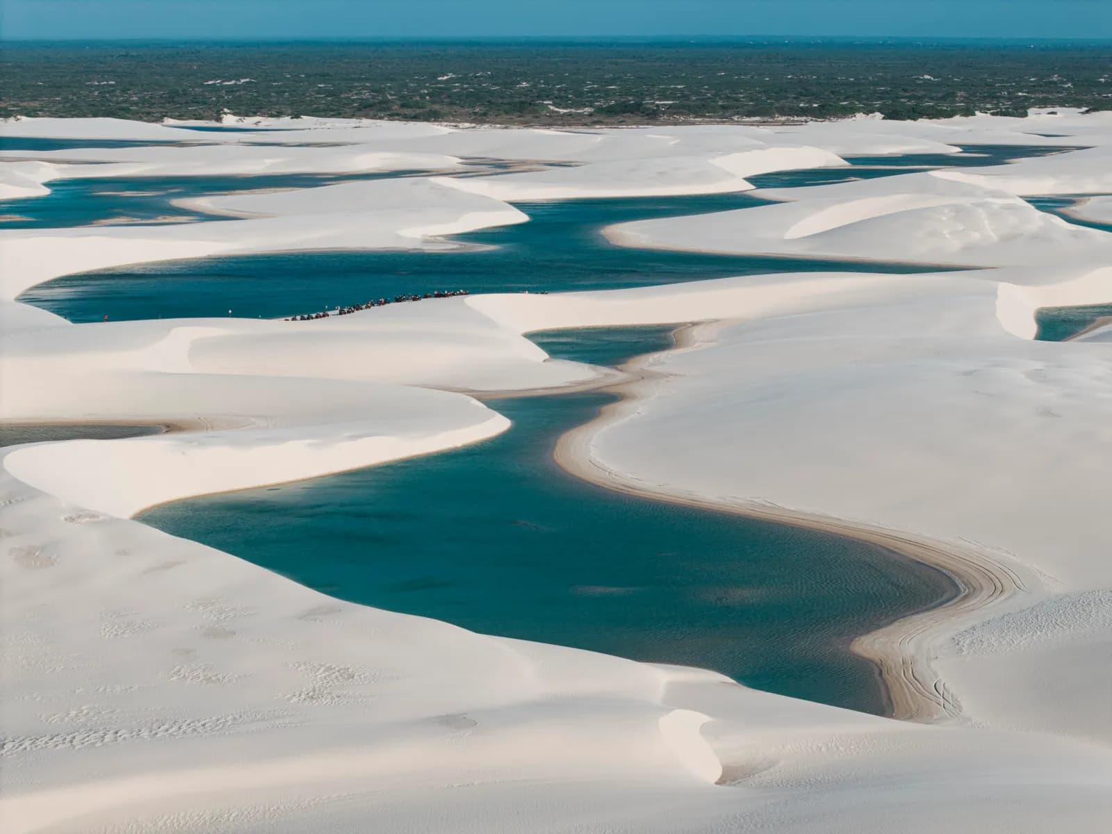 Lagoa de água azul entre as dunas brancas dos Lençóis Maranhenses, vista do alto
