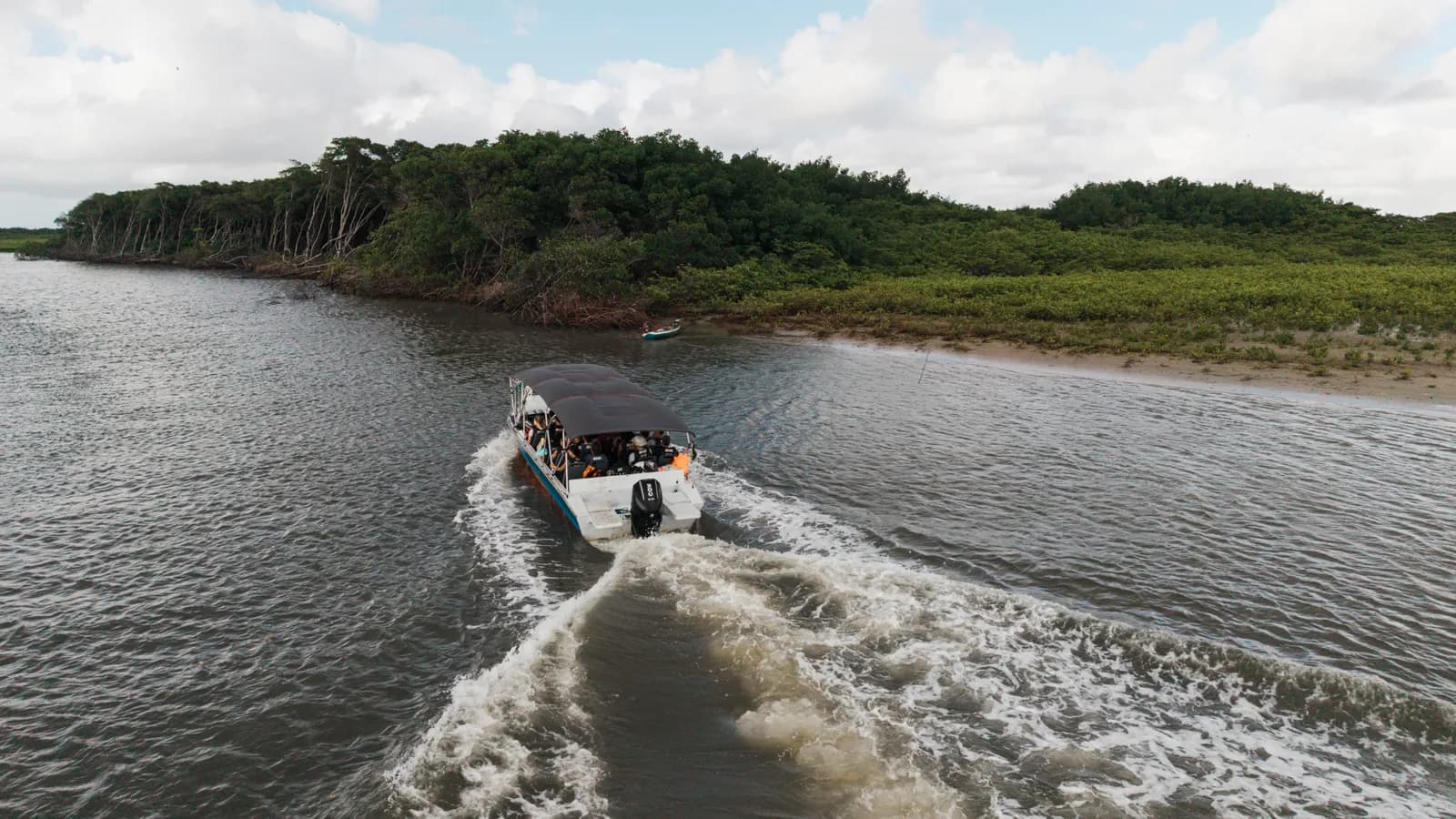 Lancha navegando pelo rio entre a vegetação, no caminho para Atins